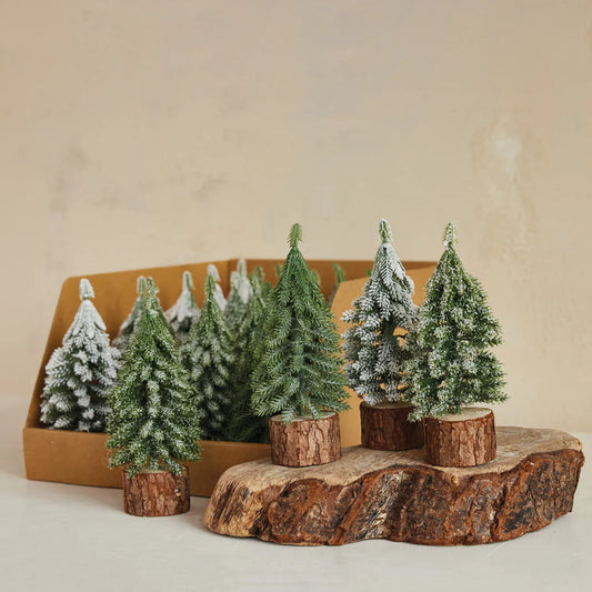Mini faux frosted and green evergreen trees on natural wood slice bases