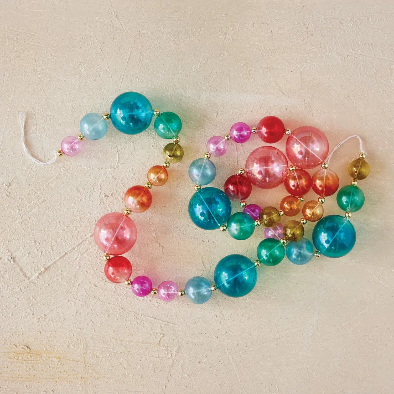 Multicolor plastic ball garland with shiny beads in teal, pink, red, and gold tones
